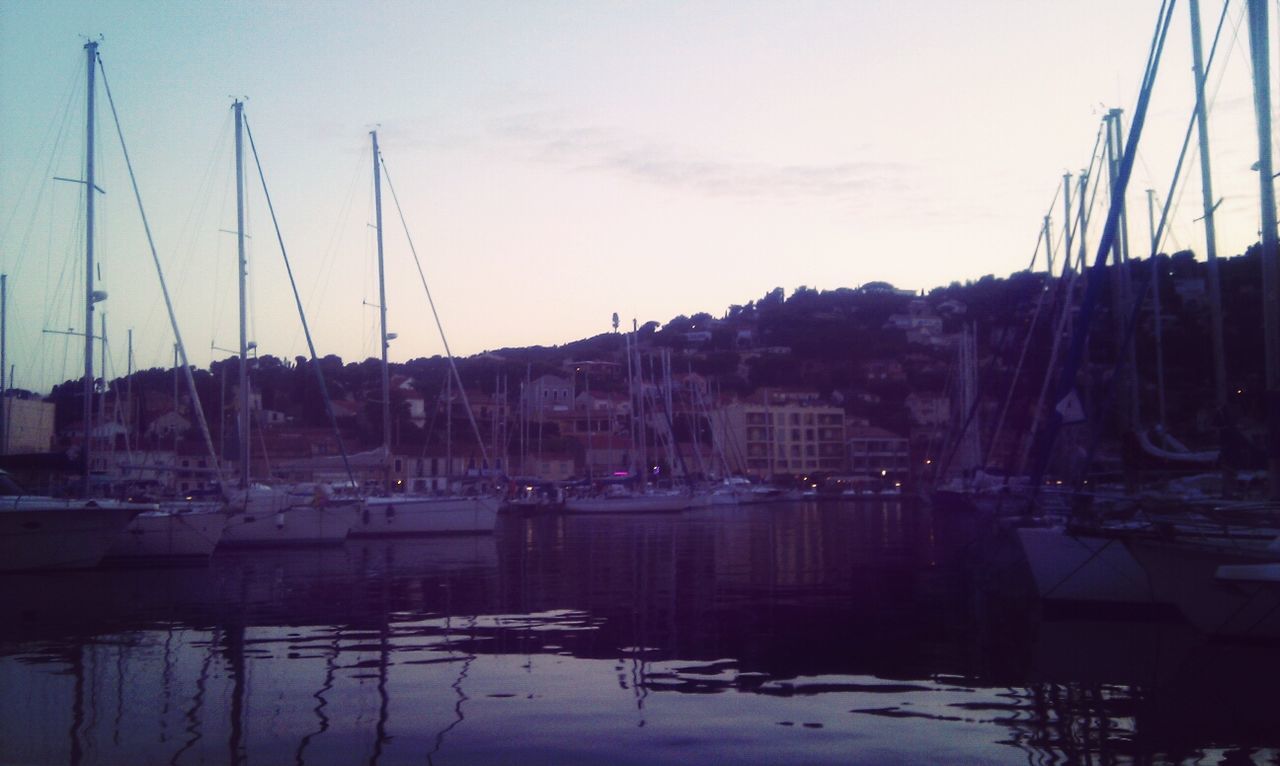 nautical vessel, moored, water, harbor, transportation, mast, boat, mode of transport, sky, built structure, waterfront, sailboat, sea, architecture, building exterior, reflection, commercial dock, river, sunset, outdoors