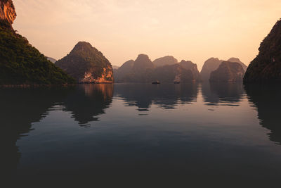 Scenic view of rocks in lake against sky during sunset