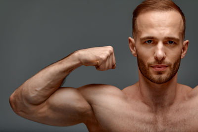 Portrait of shirtless man against black background