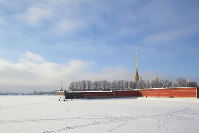 Built structure on snow covered field against sky