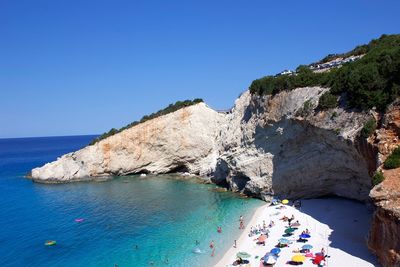 Panoramic view of sea and rocks against clear blue sky