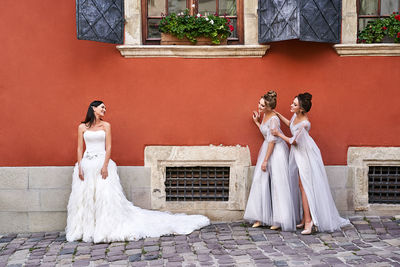 Rear view of couple standing against wall