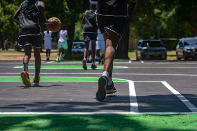 Low section of women running on basketball court 