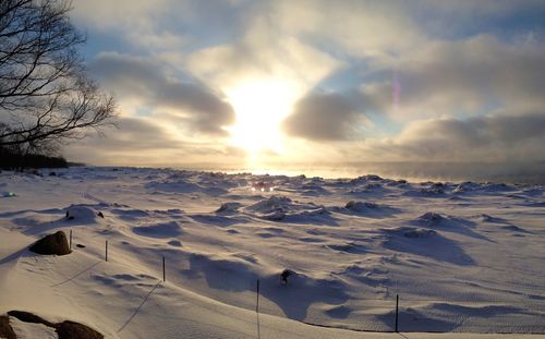 Scenic view of snow covered landscape against cloudy sky