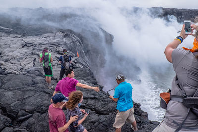 Group of people on rock against mountain