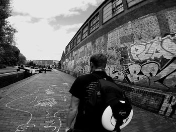 Rear view of man standing in front of building