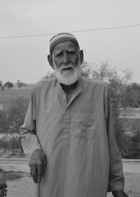 Portrait of senior man standing against sky