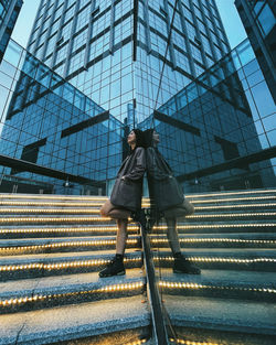 Low angle view of woman standing by modern building