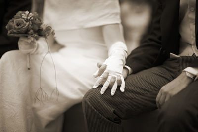 Midsection of bride and groom holding hands