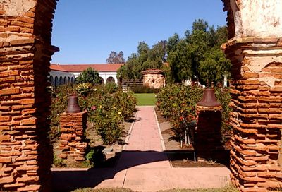 Potted plants at entrance of temple against clear blue sky