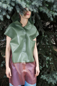 Midsection of woman standing by tree in forest