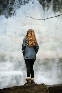 Rear view of woman looking at waterfall