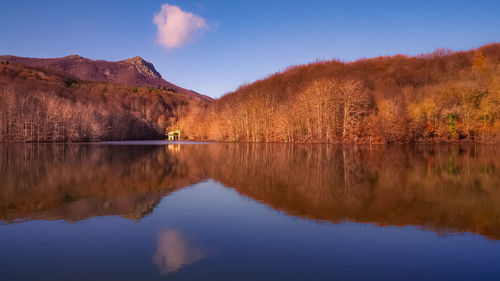 Scenic view of lake by mountain against sky