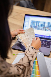 Midsection of woman using laptop on table