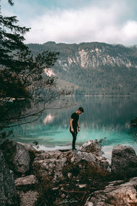 Man standing by lake against sky