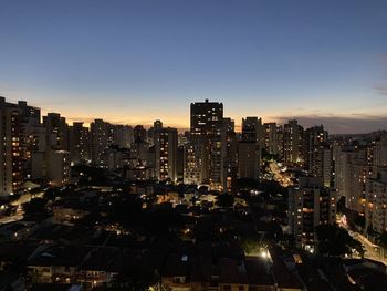 Illuminated buildings against sky at night