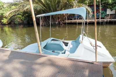 Boats moored on pier by lake