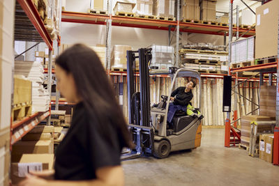 Female forklift operator looking up while working in lumber industry