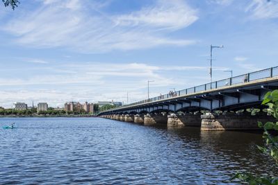 Bridge over river in city against sky