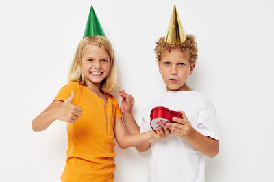 Portrait of smiling sibling against white background