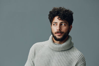 Portrait of young man against gray background