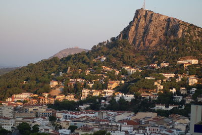 Townscape by mountain against sky