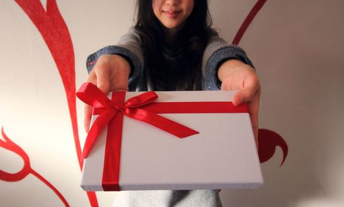 Midsection of woman holding gift