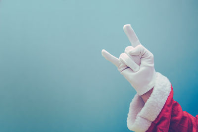 Close-up of person hand against blue background