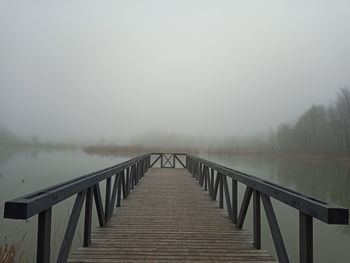 Bridge over calm lake against sky