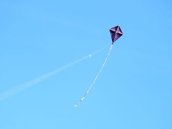 Low angle view of kite against clear blue sky