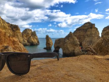 Scenic view of beach against sky with sunglasses in focus