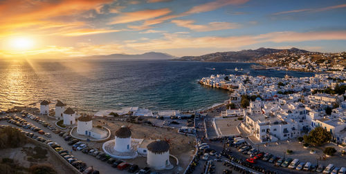 High angle view of buildings by sea against sky during sunset