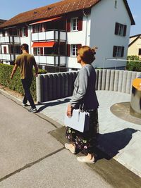 Rear view of women walking on street in city