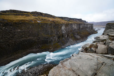 Scenic view of waterfall against sky