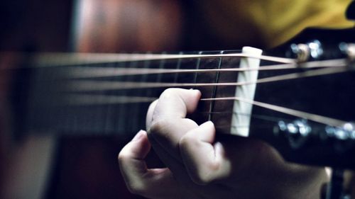 Midsection of man playing guitar