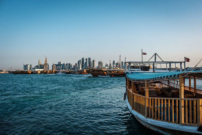 Sea by buildings against clear blue sky