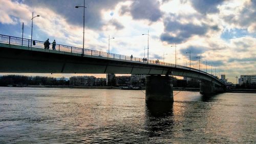 Bridge over river in city against sky