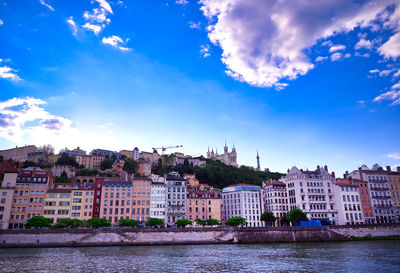 Buildings in city against cloudy sky