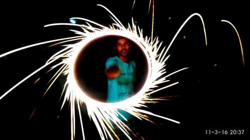 Low angle view of fireworks against sky at night