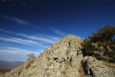 Low angle view of rock formation against sky