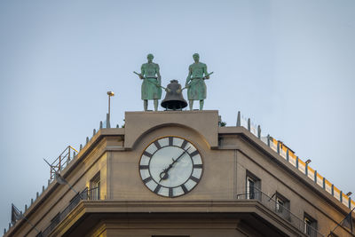 Low angle view of clock tower against clear sky