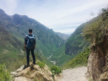 Man standing on mountain road against sky