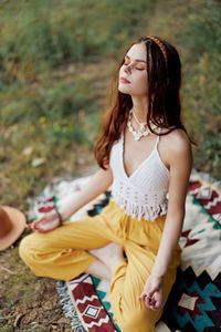 Young woman sitting on field