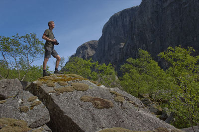 Low angle view of man standing on rock
