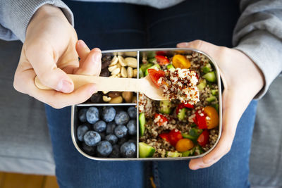 Lunchbox with quinoa salad with tomato and cucumber, blue berry and trail mix