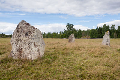 Hay bales on field against sky