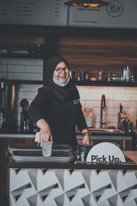 Portrait of smiling man standing in restaurant