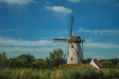 Canal with old windmill and bushes near damme. a charming country village in belgium.