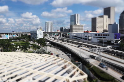 View of bridge in city against cloudy sky