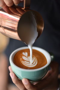 Close-up of barista making cappuccino at cafe
